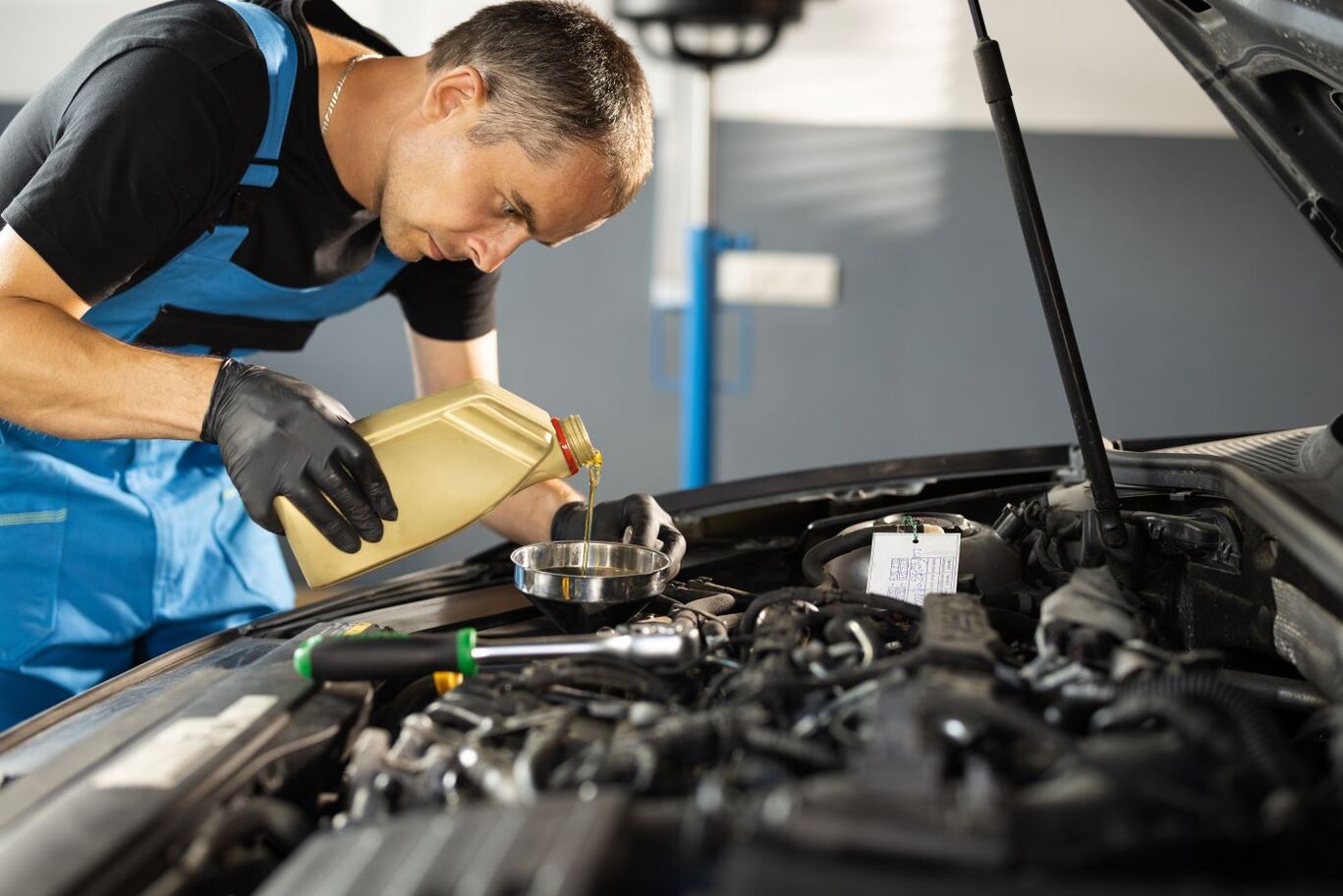 Technician pouring fresh oil during an oil change service